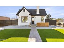 Charming renovated single-story house with manicured lawn, modern lighting, and stylish white and black paint at 2601 E Willetta St, Phoenix, AZ 85008