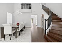 Elegant dining area with high ceilings, wood floors, and a stunning chandelier at 280 W Wisteria Pl, Chandler, AZ 85248