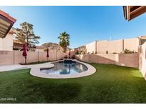 Backyard pool with artificial grass, decorative walls, and mountain views at 4346 E Corral St, Phoenix, AZ 85044