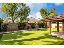 Beautiful backyard featuring lush green grass, mountain views, a charming pergola, and a well-manicured brick wall at 4525 N 66Th E St # 55, Scottsdale, AZ 85251