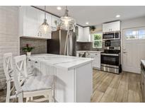 Modern kitchen features white cabinets, stainless steel appliances, and a stylish marble countertop island at 4800 N 68Th St # 225, Scottsdale, AZ 85251