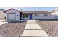Charming home featuring decorative gravel, a concrete walkway, and a vibrant blue front door at 7807 E Palm Ln, Scottsdale, AZ 85257
