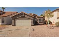 Charming single-story home featuring a terra cotta roof, desert landscaping, and a two-car garage at 8910 W Lockland Ct, Peoria, AZ 85382