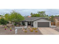 Charming single-story home boasts a desert landscaped yard, warm paint, and a two-car garage at 9621 N 83Rd Way, Scottsdale, AZ 85258