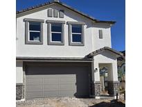 Two-story home with a gray garage door, stone accents, and a white stucco exterior at 9835 S 11Th St, Phoenix, AZ 85042