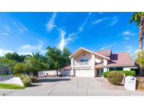 Charming two-story home with a well-manicured front yard and beautiful desert landscaping at 10421 N 77Th Pl, Scottsdale, AZ 85258