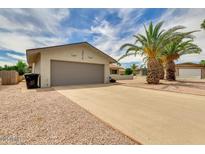 Charming single-story home featuring desert landscaping and a spacious driveway leading to an attached two-car garage at 1135 S Longwood Loop, Mesa, AZ 85208