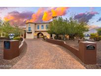 Elegant two-story home featuring a charming stone-paved driveway and beautiful desert landscaping at 12980 E Cochise Rd, Scottsdale, AZ 85259