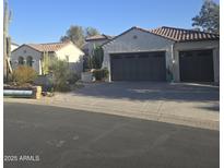 Charming home featuring desert landscaping, three-car garage, and a terracotta tile roof at 16488 W Windsor Ave, Goodyear, AZ 85395