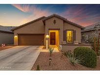 Charming single-story home with a well-manicured front yard and inviting curb appeal during a beautiful sunset at 20780 N Gardenia Rd, Maricopa, AZ 85138