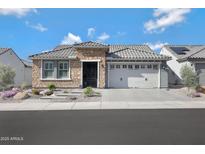 Charming single-story home with stone accents, tile roof, a two-car garage, and professionally landscaped front yard at 26764 W Ponderosa Ln, Buckeye, AZ 85396