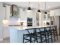 Bright, modern kitchen featuring a large island with seating, stainless steel appliances, and stylish pendant lighting at 26764 W Ponderosa Ln, Buckeye, AZ 85396