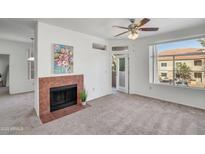 Bright living room featuring a fireplace, ceiling fan, and a view to the community outside at 3830 E Lakewood E Pkwy # 2009, Phoenix, AZ 85048