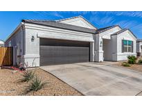 Charming single-story home featuring a dark gray garage door and a well-maintained gravel yard at 5180 E Diatomite Dr, San Tan Valley, AZ 85143