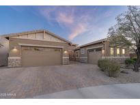 Charming home featuring a three-car garage, desert landscaping, and a brick driveway at 6515 W Copper Springs Rd, Phoenix, AZ 85083