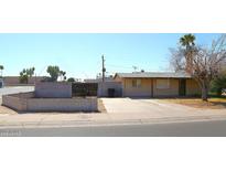 Charming single-story home with a long driveway and gated front yard at 1209 W 1St Pl, Mesa, AZ 85201