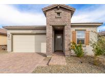 Charming home exterior featuring a brick entryway, two-car garage, and well-maintained landscaping at 13314 W Dale Ln, Peoria, AZ 85383