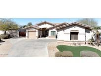 Beautful stucco home with a tile roof, mature trees, manicured lawn and a long driveway at 13350 W La Reata Ave, Goodyear, AZ 85395