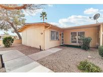 Tan home with a concrete walkway and rock landscaping, offering a secure and charming curb appeal at 13354 W Stonebrook Dr, Sun City West, AZ 85375