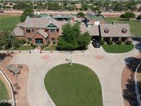 Expansive estate featuring a circular driveway, mature trees, and a well-manicured lawn at 2025 S Val Vista Dr, Gilbert, AZ 85295