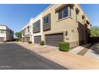 A row of modern townhomes featuring neutral colors, individual garages, and well-maintained landscaping at 7324 E Vista Bonita Dr, Scottsdale, AZ 85255