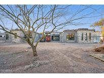 Unfinished home exterior featuring stone accents, large windows, and desert landscaping potential at 8230 N Mockingbird Ln, Paradise Valley, AZ 85253