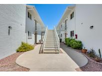 Apartment building exterior with white painted brick and stairs leading to the upper levels at 920 N 82Nd N St # H203, Scottsdale, AZ 85257