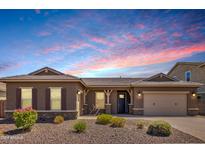 Front exterior of a single story home featuring stone accents, desert landscaping, and three car garage at 10131 W El Cortez Pl, Peoria, AZ 85383