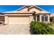 Charming single-story home with a two-car garage, desert landscaping, and a tile roof at 18525 N 85Th N Ave, Peoria, AZ 85382