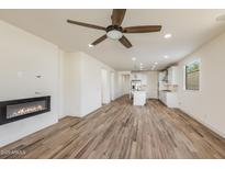 Spacious living room featuring a fireplace, wood floors, and an open floor plan at 2113 N 210Th Ave, Buckeye, AZ 85396