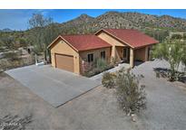 Inviting single-story home with a spacious driveway, two-car garage, and mountain views at 30066 N Holly Dr, San Tan Valley, AZ 85144