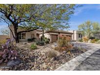 Charming single-story home featuring a desert landscaped front yard and attached two car garage at 33250 N 71St St, Scottsdale, AZ 85266