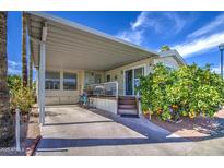 Charming home with covered parking, a front deck, and a lovely orange tree on a sunny day at 7750 E Broadway Rd # 475, Mesa, AZ 85208