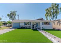 Charming single-story home featuring a manicured lawn, blue shutters and inviting front porch at 1749 E Medlock Dr, Phoenix, AZ 85016