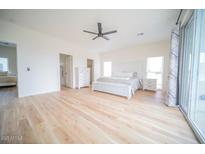 Bright main bedroom features a ceiling fan, light wood floors, and a sliding glass door at 2441 W Morten Ave, Phoenix, AZ 85021