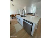 Bright kitchen features an island with a sink and stainless steel dishwasher at 2444 W Morten Ave, Phoenix, AZ 85021