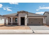 Charming single-story home with a two-car garage and a well-manicured lawn at 26957 W Lone Cactus Dr, Buckeye, AZ 85396