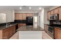 Well-equipped kitchen featuring granite countertops, sleek appliances, and a center island at 46072 W Barbara Ln, Maricopa, AZ 85139