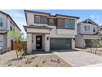 Beautiful two-story home with a modern design, dark gray garage door, and inviting stone-accented entrance at 7987 W Griswold Rd, Peoria, AZ 85345