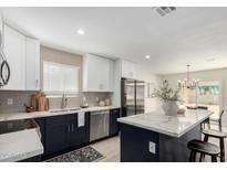 Well-designed kitchen featuring white cabinets, stainless steel appliances, and a large island with marble countertops at 25620 S Cloverland Dr, Sun Lakes, AZ 85248