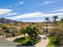 Expansive estate showcasing lush landscaping, mature trees, circular drive and views of mountains at 4201 E Claremont Ave, Paradise Valley, AZ 85253