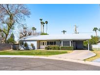 Charming single-story home with desert landscaping, a covered carport, and a light gray color scheme at 508 W Harmont Dr, Phoenix, AZ 85021