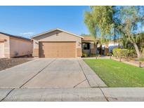 Charming single-story home featuring a well-manicured lawn and a convenient two-car garage and low maintenance landscaping at 1030 E Desert Moon Trl, San Tan Valley, AZ 85143