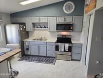 Well-lit kitchen features gray cabinetry, modern stainless steel appliances, and a stylish backsplash at 10624 W Oakmont Dr, Sun City, AZ 85351