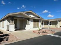 Cozy single-story home featuring a well-manicured desert landscape and charming facade at 11596 W Sierra Dawn Blvd # 99, Surprise, AZ 85378