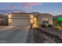 Charming single-story home with a two-car garage, desert landscaping and inviting curb appeal at dusk at 13529 W Remuda Dr, Peoria, AZ 85383