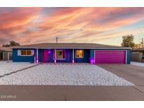 Charming single-story home featuring unique gravel landscaping and colorful pink garage door at 1435 W 6Th St, Mesa, AZ 85201