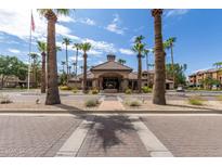 Elegant community clubhouse featuring manicured landscaping, palm trees, and a welcoming entrance at 14950 W Mountain View Blvd # 5207, Surprise, AZ 85374