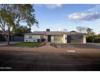 Charming single-story home featuring fresh paint, a landscaped yard, and a two-car garage at 1610 W Dunlap Ave, Phoenix, AZ 85021