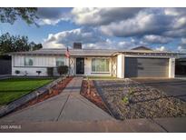 Charming single-story home featuring a landscaped yard, fresh paint, and a two-car garage at 1610 W Dunlap Ave, Phoenix, AZ 85021